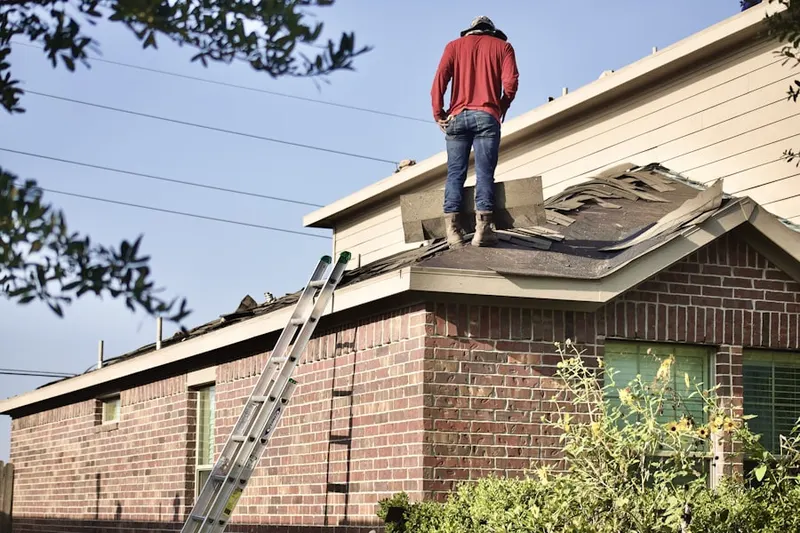 Professional roofer working on a residential roof in Necombtown